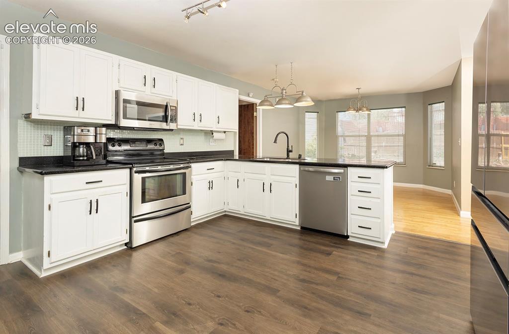 Image 3 of 32: Kitchen featuring white cabinetry, stone countertops, stainless steel appli