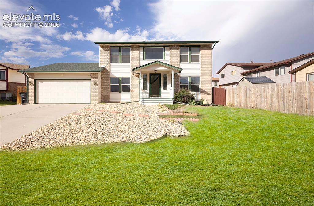 Image 6 of 32: Two-story residence featuring a brick and siding exterior, an attached two-