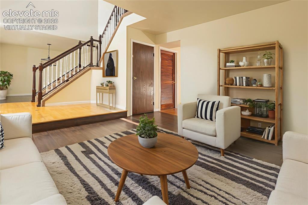 Image 8 of 32: Inviting living area featuring rich wood-finish flooring, a prominent stair
