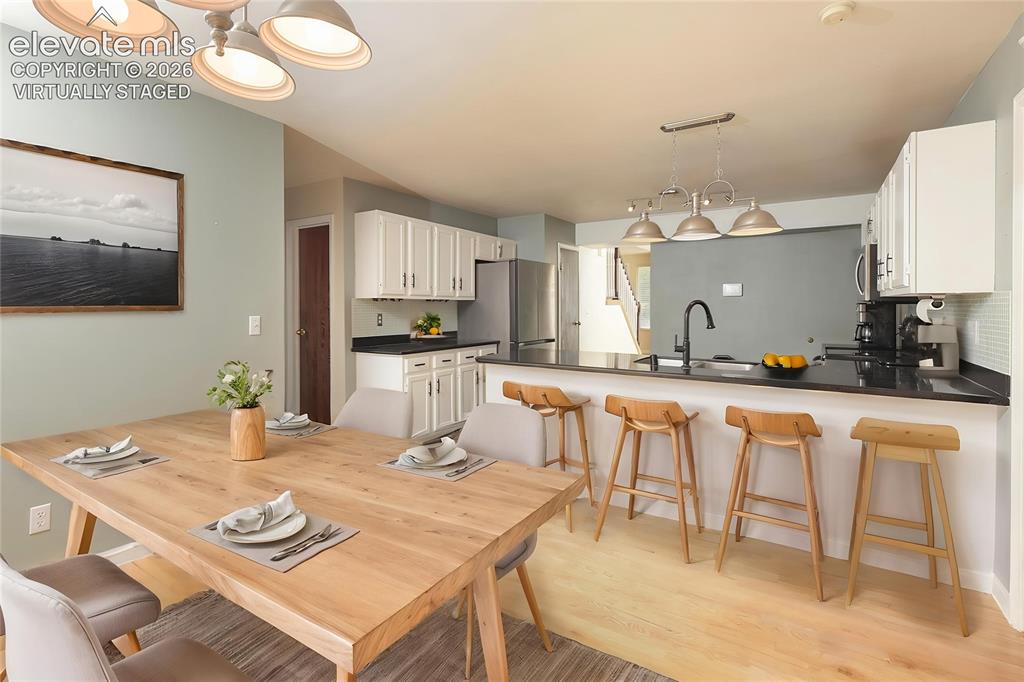 Image 9 of 32: 2nd Dinning area featuring stone countertops, white cabinetry with dark har