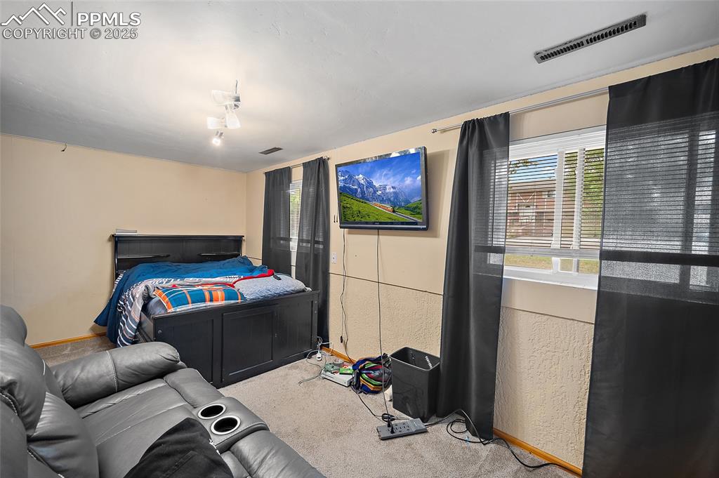 Image 10 of 49: Carpeted bedroom with a textured wall and baseboards