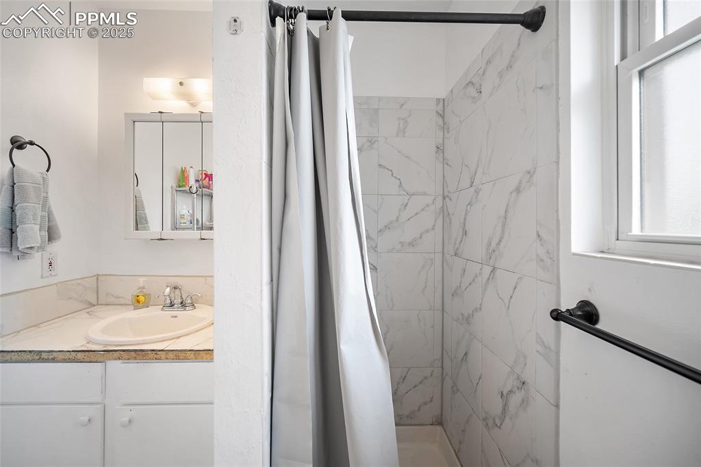 Image 19 of 49: Full bath with a shower stall and vanity