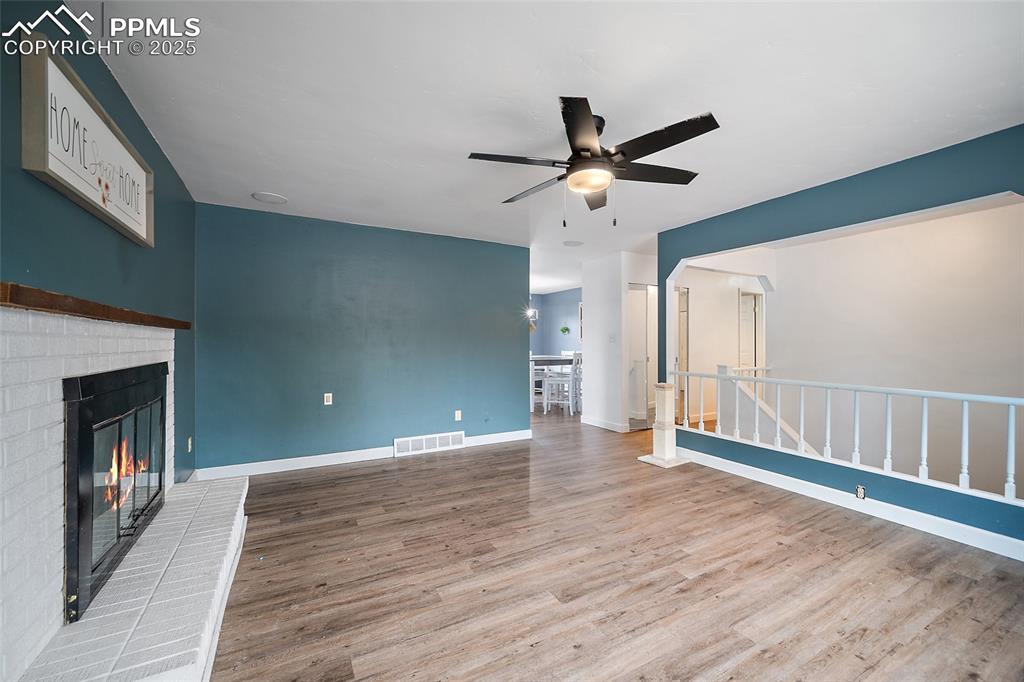 Image 24 of 49: Unfurnished living room featuring light wood-type flooring, a fireplace, ce