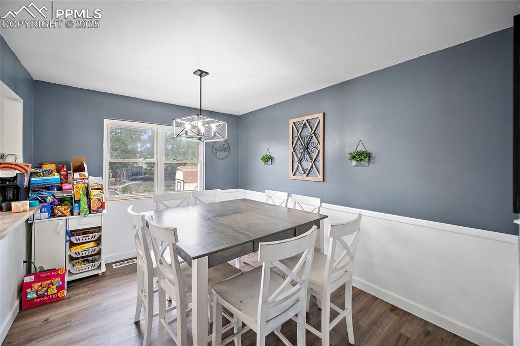 Image 25 of 49: Dining space featuring dark wood finished floors and a chandelier