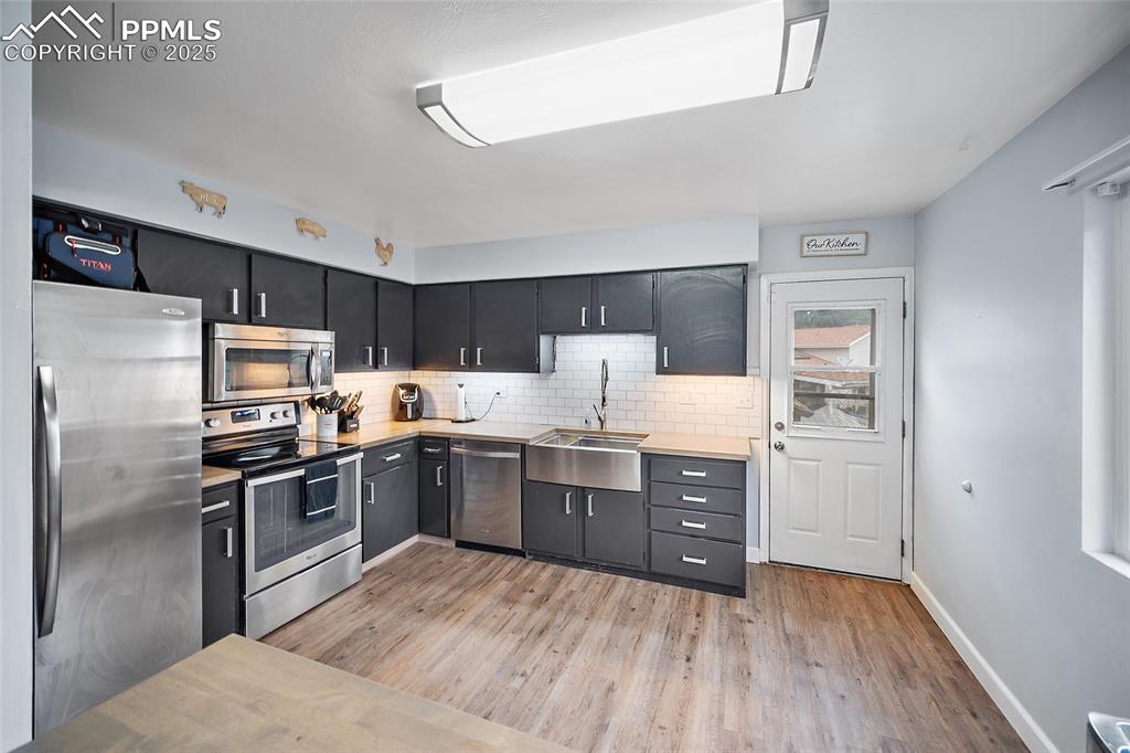 Image 28 of 49: Kitchen featuring appliances with stainless steel finishes, tasteful backsp