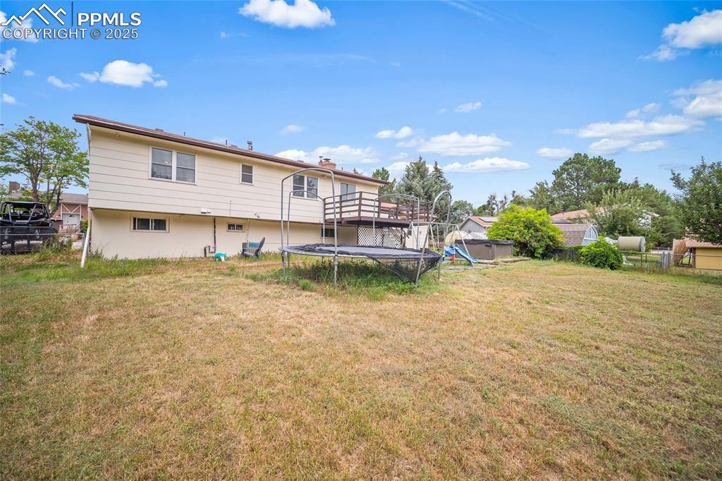 Image 35 of 49: Rear view of property featuring a trampoline