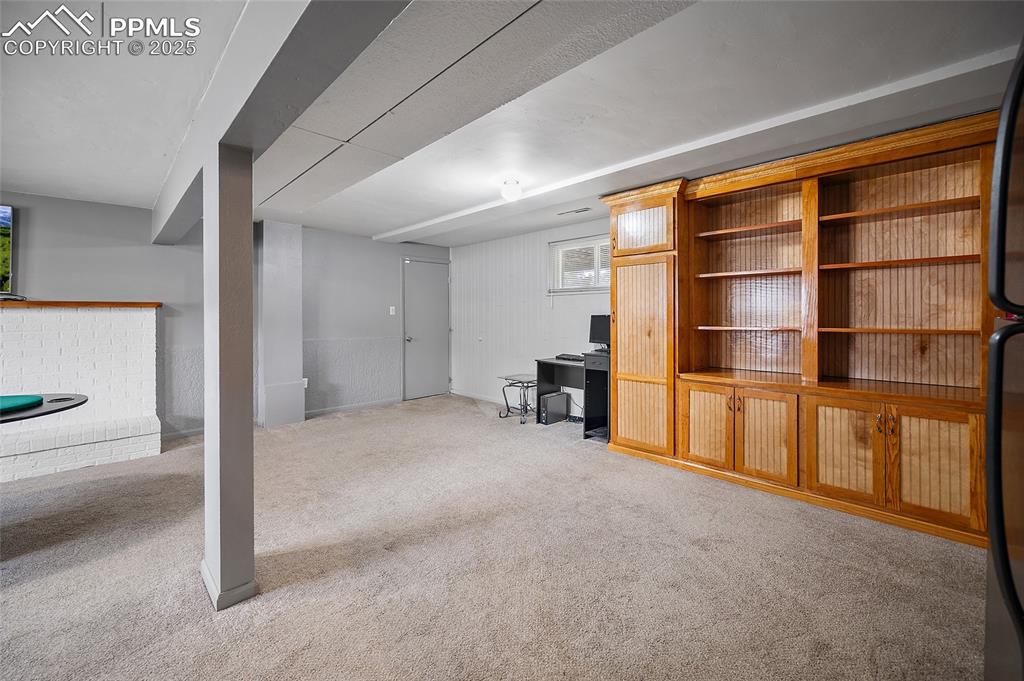 Image 5 of 49: Basement featuring light carpet and wood walls