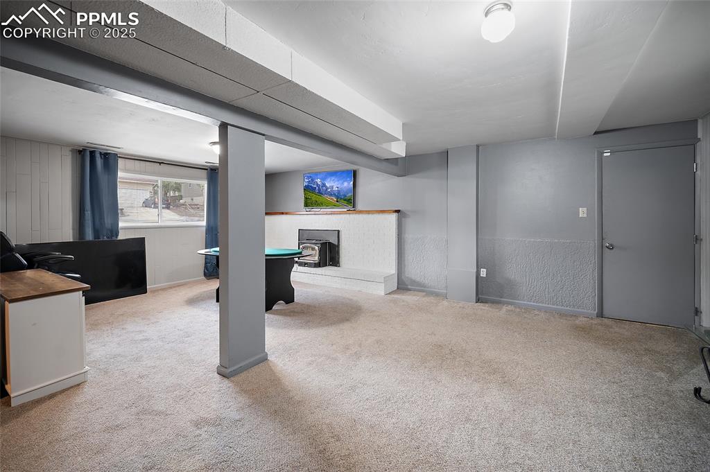 Image 6 of 49: Below grade area featuring light carpet and a fireplace