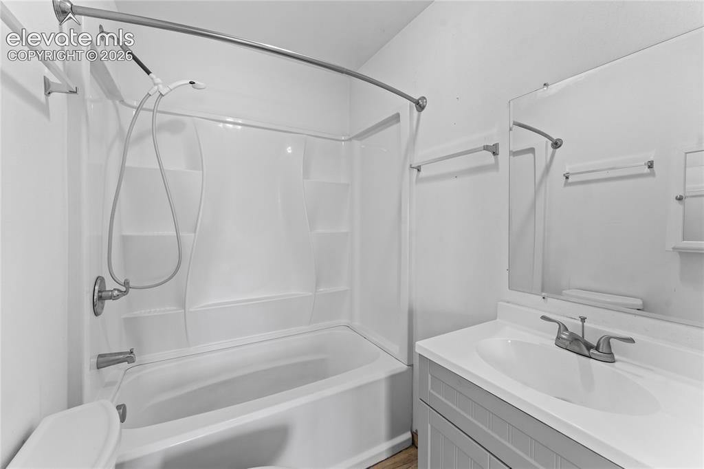 Image 14 of 20: Bathroom featuring a white bathtub and shower combination with a shower cur