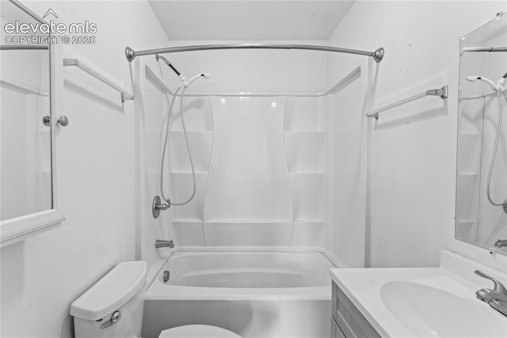Image 15 of 20: Bathroom featuring a white tub-shower combination with built-in shelving, c