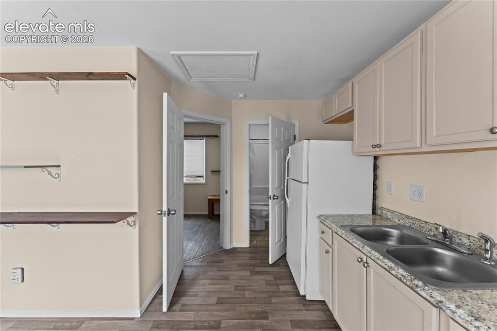 Image 5 of 20: Kitchenette featuring neutral cabinetry, a double basin stainless steel sin