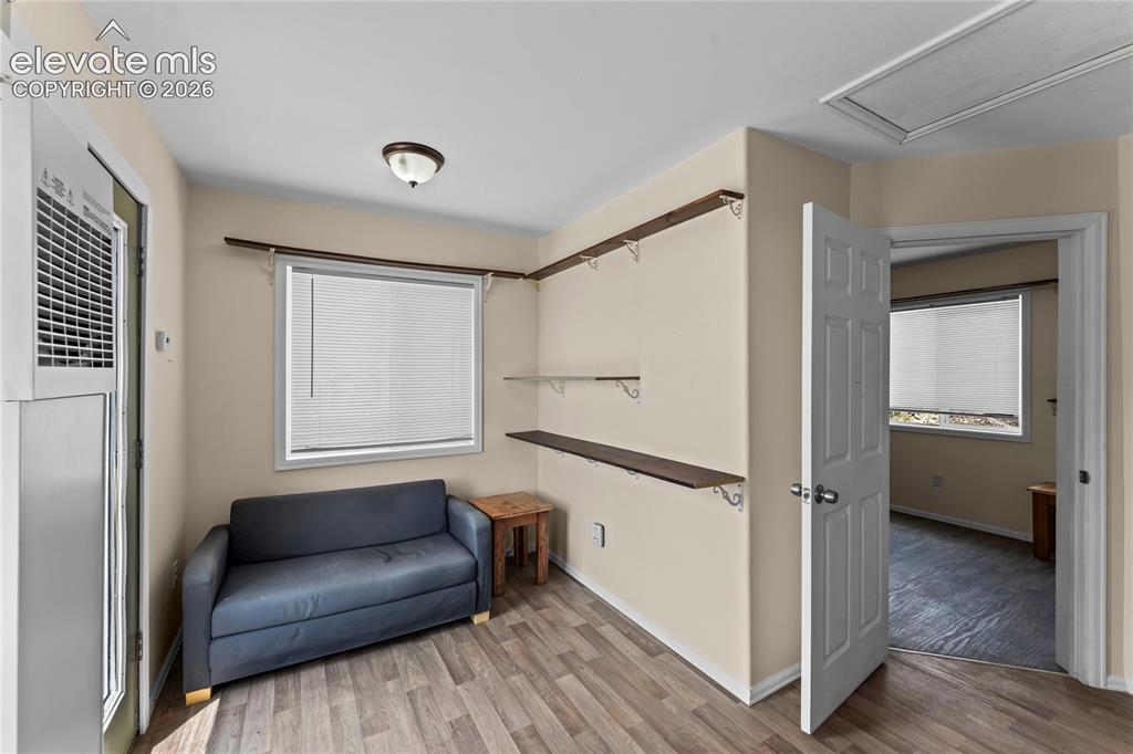 Image 6 of 20: Versatile room featuring wood-finish flooring, neutral paint, and built-in