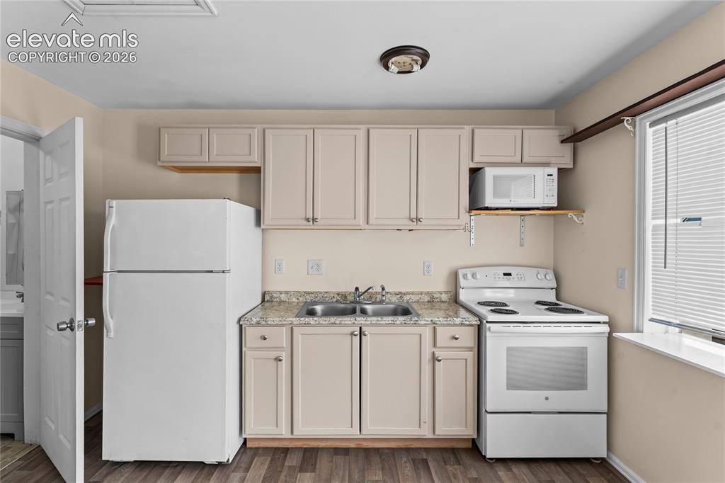 Image 8 of 20: Compact kitchen featuring wood-finish flooring, light-colored cabinetry, a