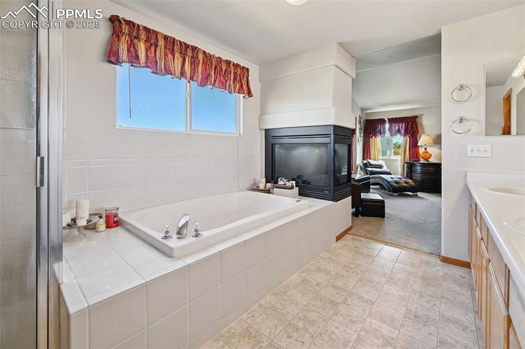 Image 42 of 47: Fireplace in the 5 piece primary  bathroom 
