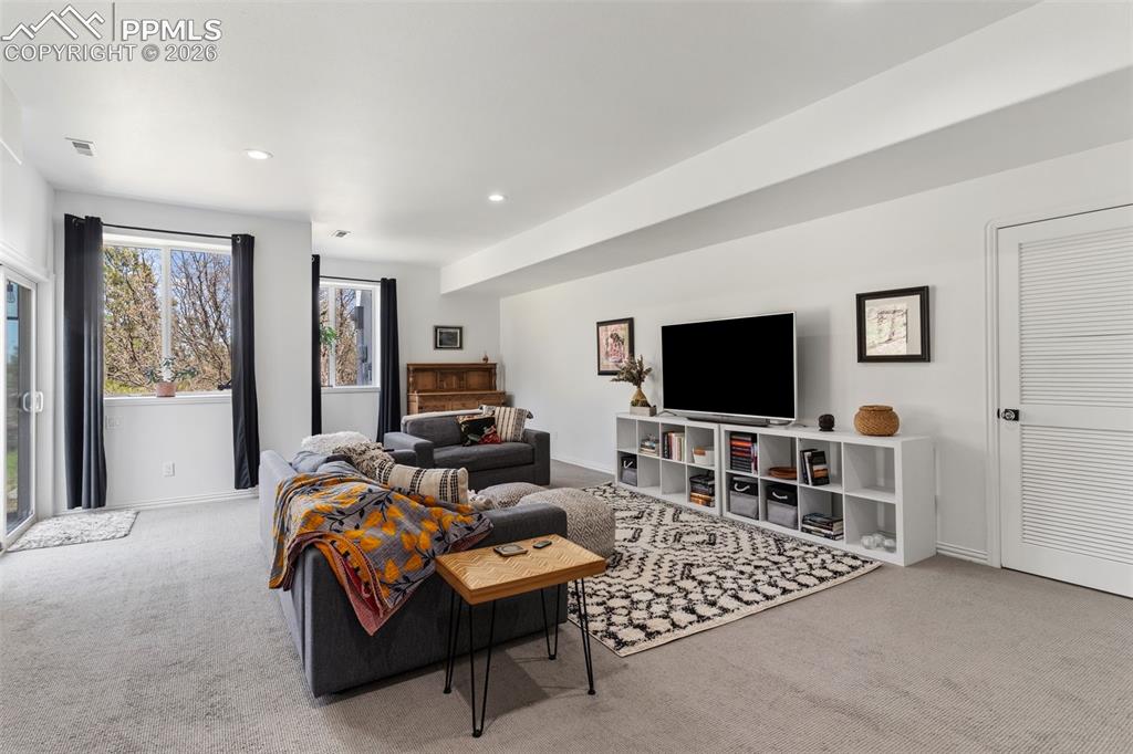Image 27 of 49: Bright & spacious basement rec room with high ceilings, large windows and a