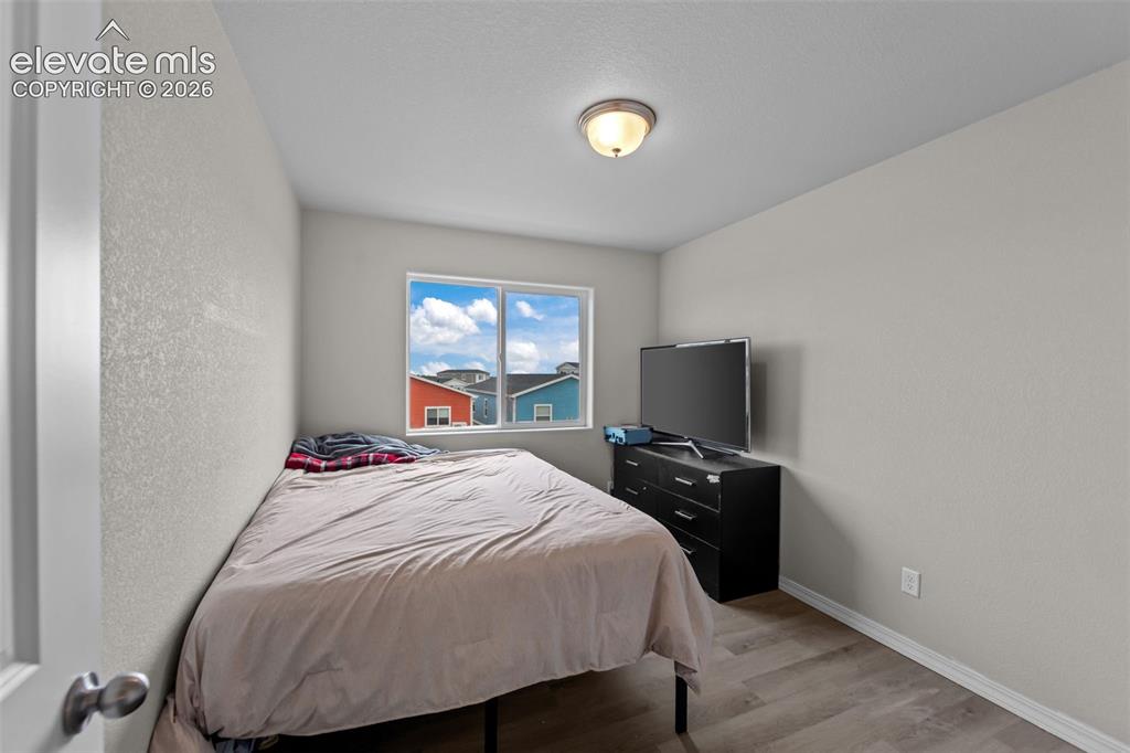 Image 16 of 32: Recessed lighting, wood-finish flooring, and a window with white trim