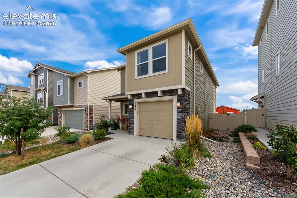 Image 2 of 32: Two-story residence featuring composite siding, stone veneer accents, an at
