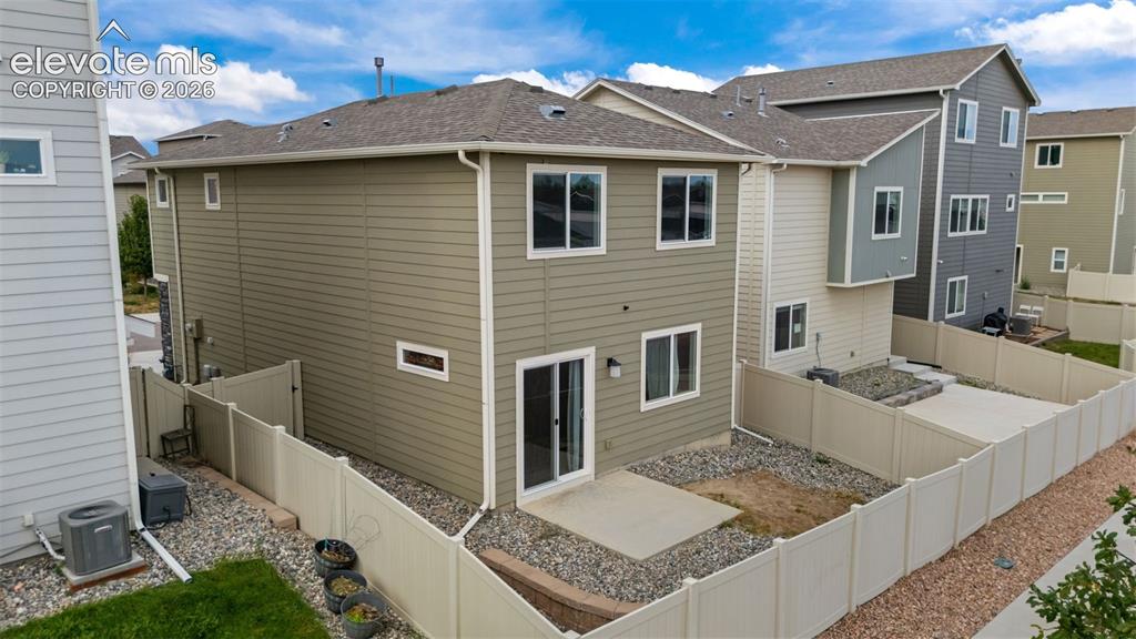 Image 21 of 32: Rear exterior featuring horizontal siding, multiple windows, and a sliding