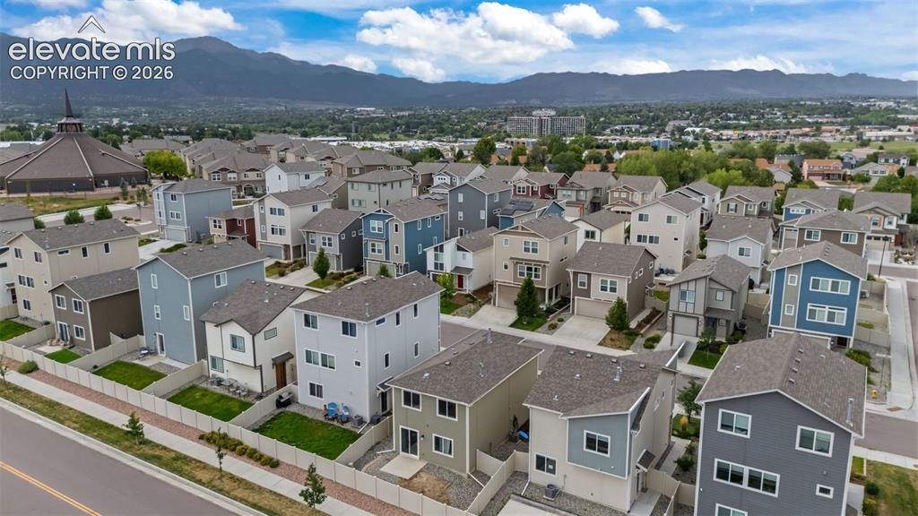 Image 27 of 32: Residential development featuring multi-story homes with varied exterior fi