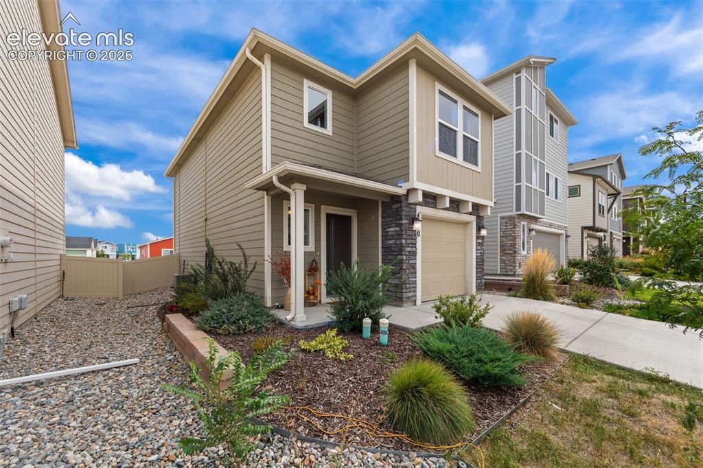 Image 3 of 32: Exterior featuring horizontal siding, stone veneer accents, an attached gar