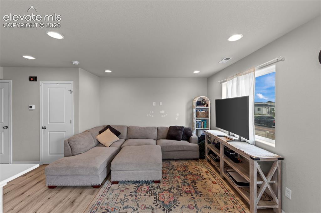 Image 6 of 32: Recessed ceiling lighting, wood-finish flooring, white trim, and light gray