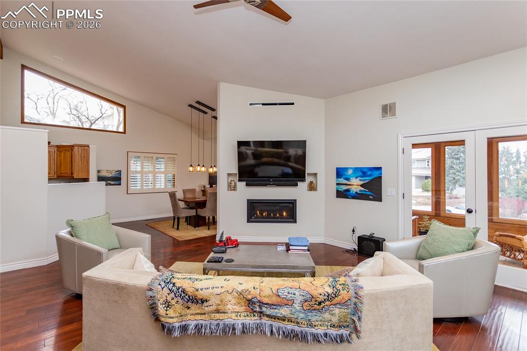 Image 11 of 45: More windows in the living room, ceiling fan, vaulted ceilings - access to 