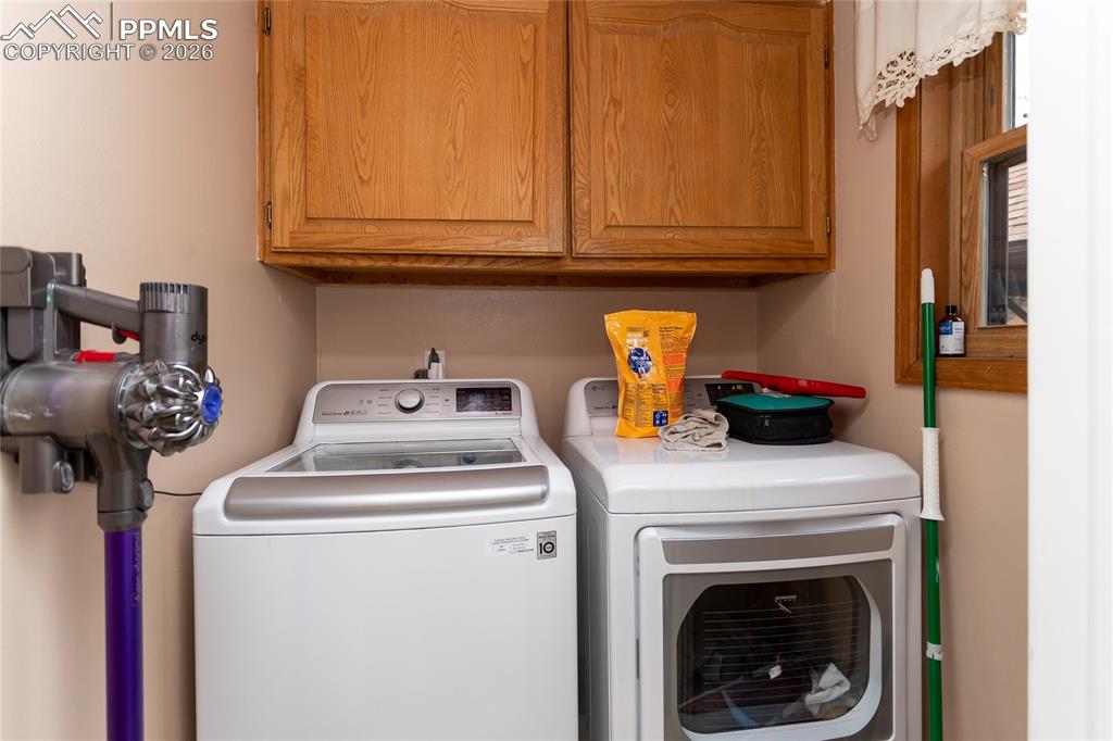 Image 30 of 45: Main level laundry room off of the kitchen with plenty of storage.
