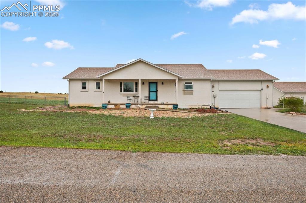 Caption: Ranch-style home with an attached garage, driveway, and stucco siding