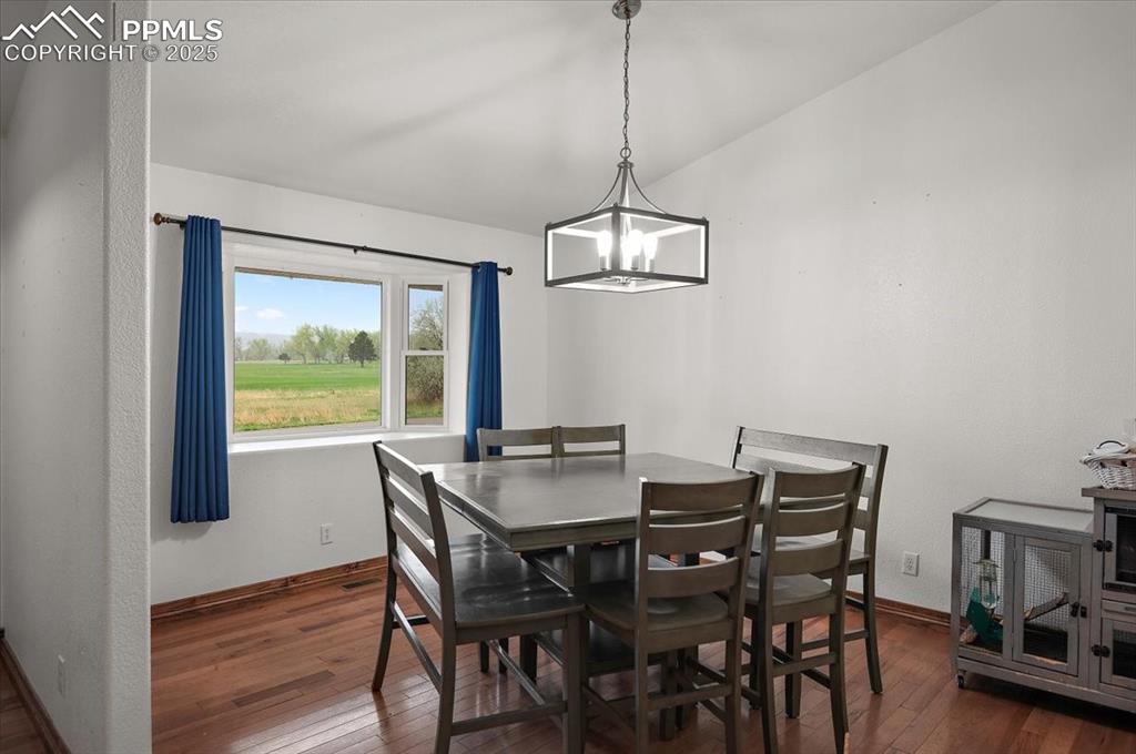 Image 11 of 38: Dining space with hardwood / wood-style floors, baseboards, and a chandelie