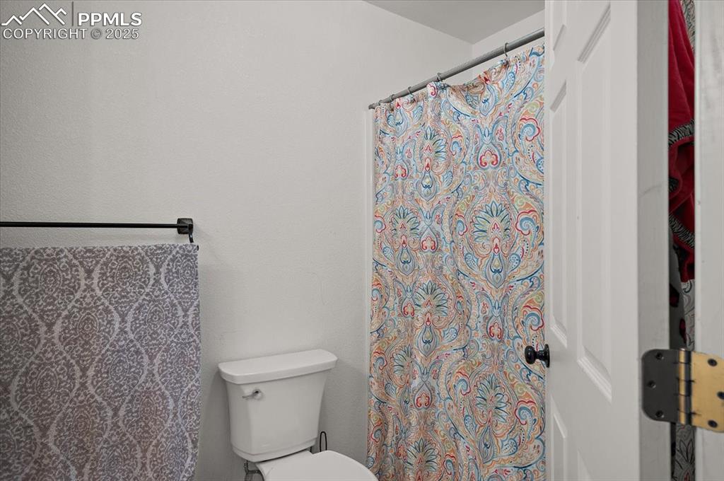 Image 19 of 38: Full bath featuring toilet and a shower with shower curtain