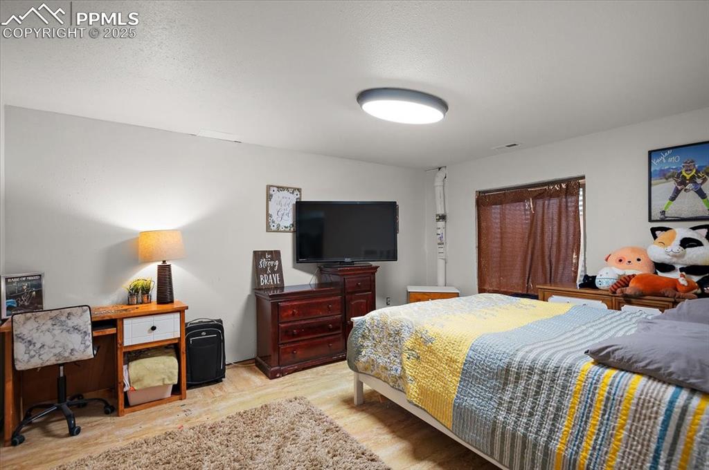 Image 26 of 38: Bedroom with light wood-style floors