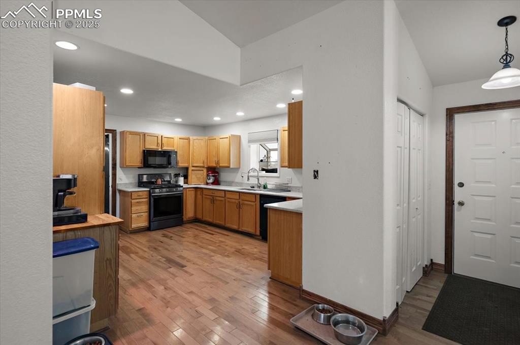Image 3 of 38: Kitchen featuring black appliances, a sink, light countertops, light wood-s