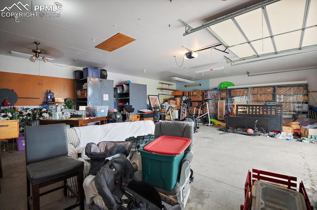 Image 34 of 38: Garage featuring ceiling fan and a garage door opener