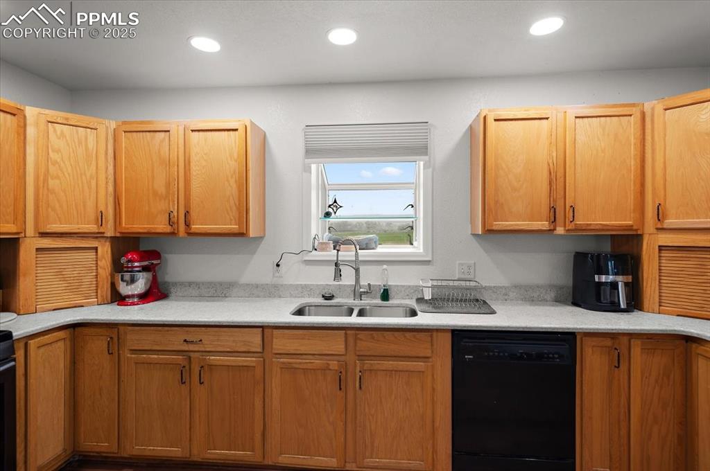 Image 8 of 38: Kitchen with black dishwasher, a sink, light countertops, and recessed ligh