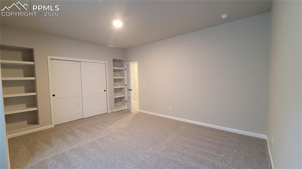 Image 25 of 33: 3rd Bedroom, with built-in shelving, located in the lower level! 