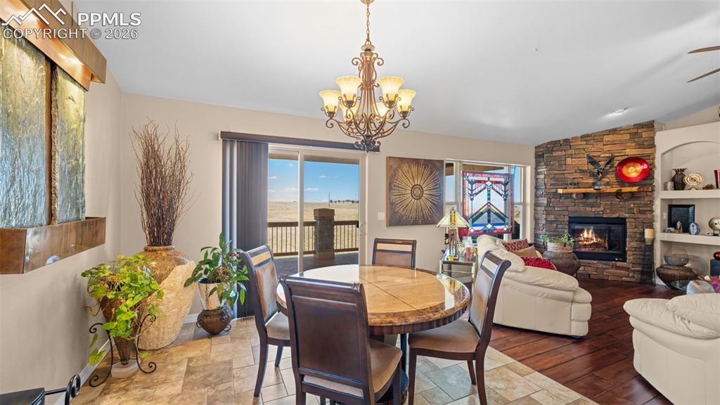 Image 10 of 50: Dining area featuring a stone fireplace, plenty of natural light, suspended