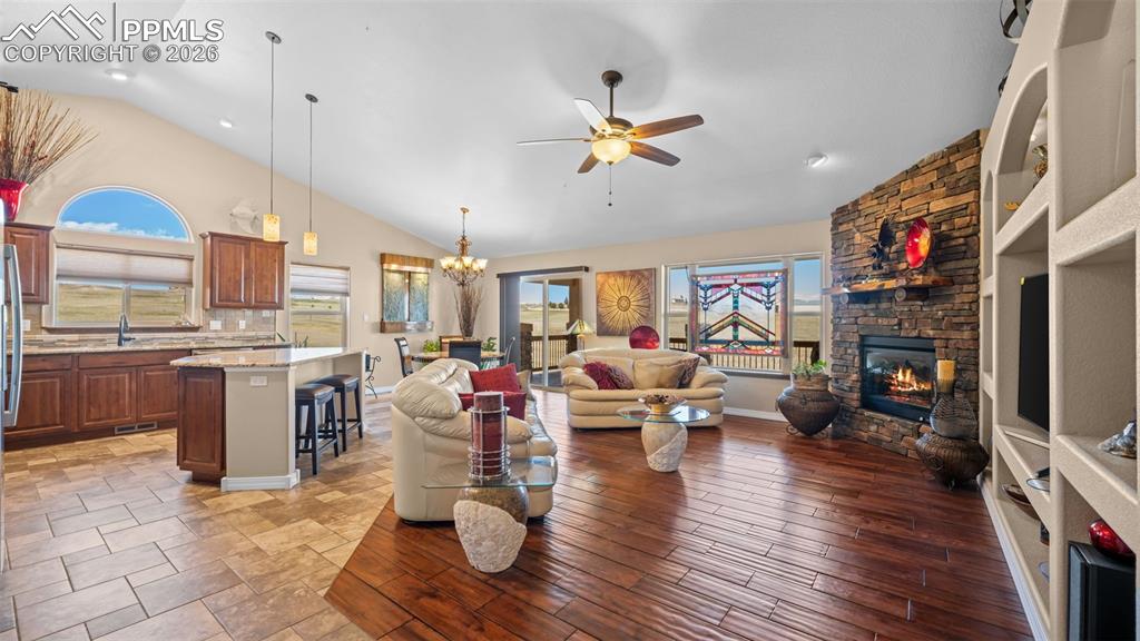 Image 12 of 47: Living area with vaulted ceiling, a ceiling fan, suspended lighting, and a 