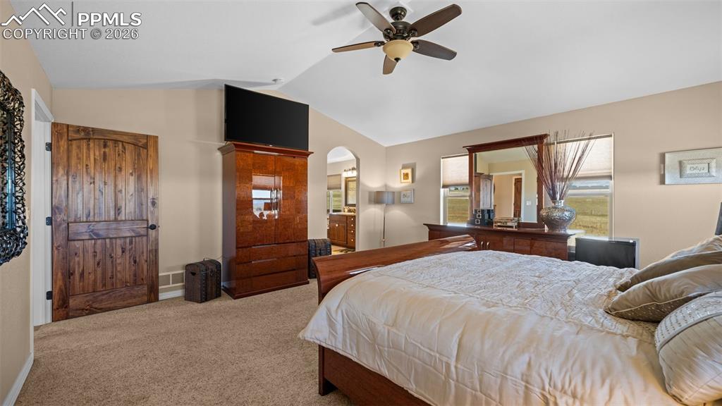 Image 21 of 47: Primary bedroom, arched walkways, ceiling fan, and ensuite bathroom