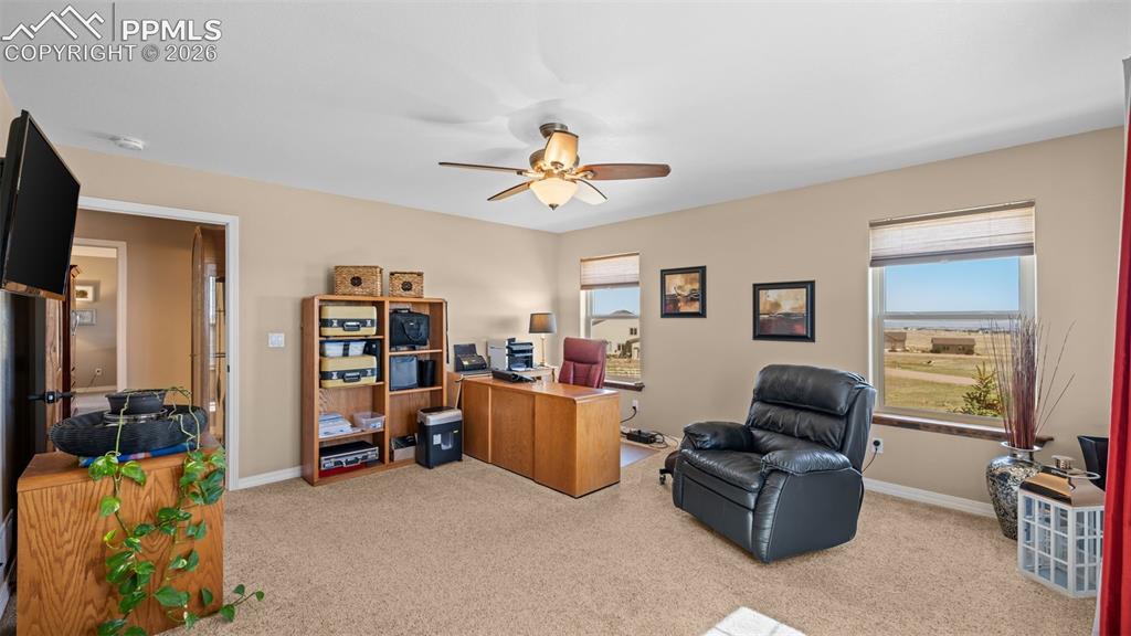 Image 28 of 50: Bedroom, currently used as an office, healthy amount of natural light, and