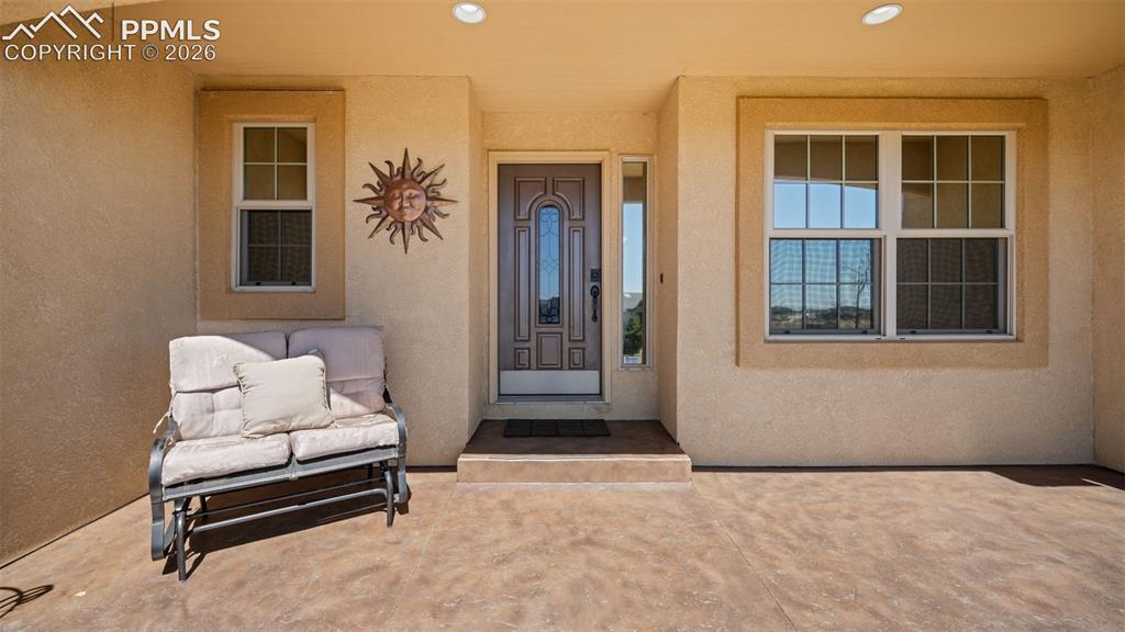Image 3 of 50: View of exterior entry with stucco siding and a stamped concrete porch