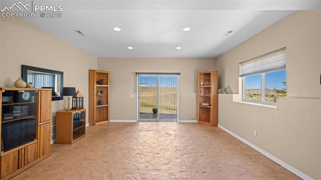 Image 36 of 47: Walk out basement with polished, stamped concrete flooring and recessed lig