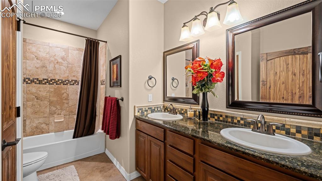 Image 39 of 47: Bathroom with double vanity and shower / tub combo