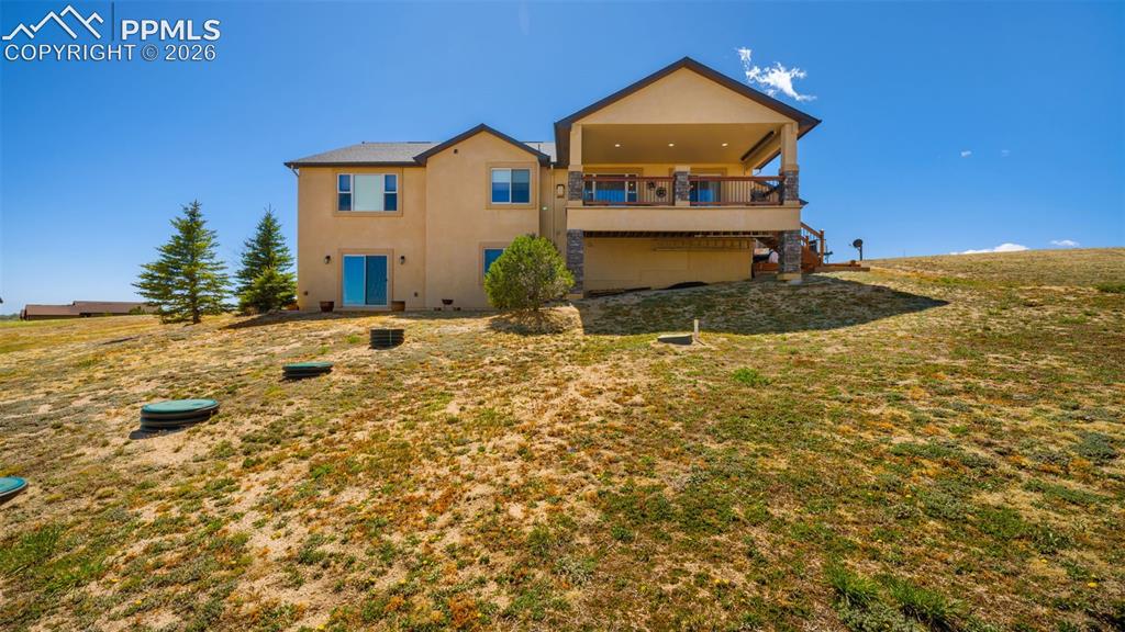 Image 44 of 50: Rear view of property with stucco siding covered deck and recessed lighting