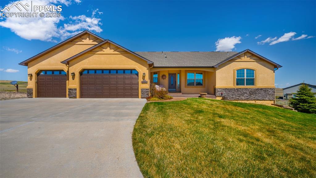 Image 47 of 47: View of front of property featuring stucco siding, stone accent, a 3 car ga