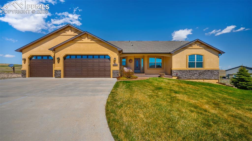 Image 47 of 50: View of front of property featuring stucco siding, stone accent, a 3 car ga