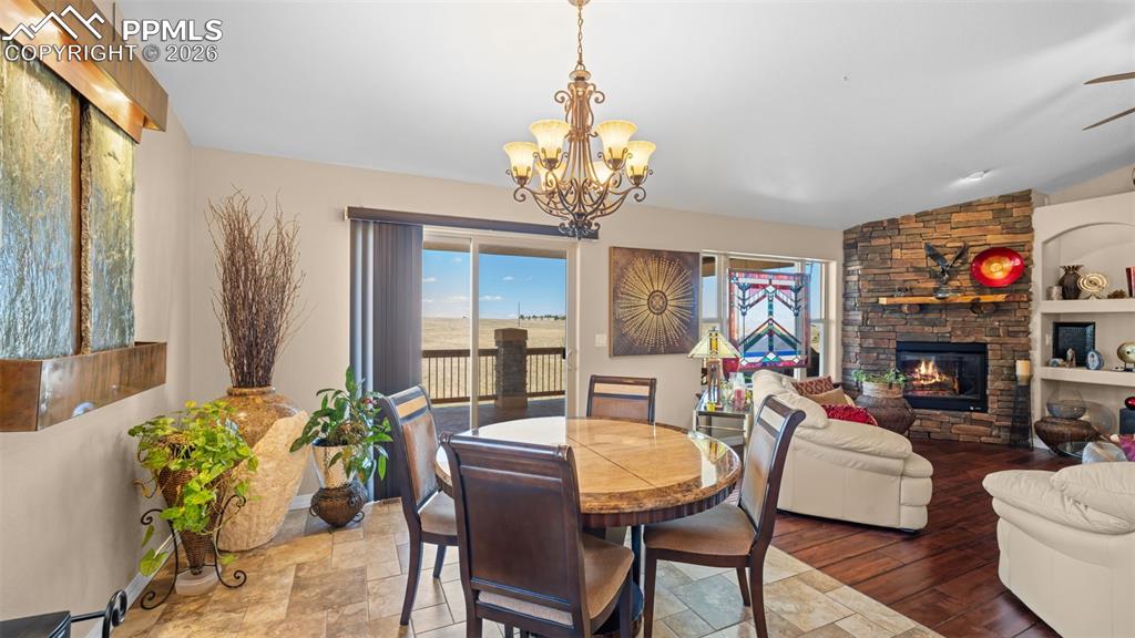 Image 9 of 47: Dining area featuring a stone fireplace, plenty of natural light, suspended