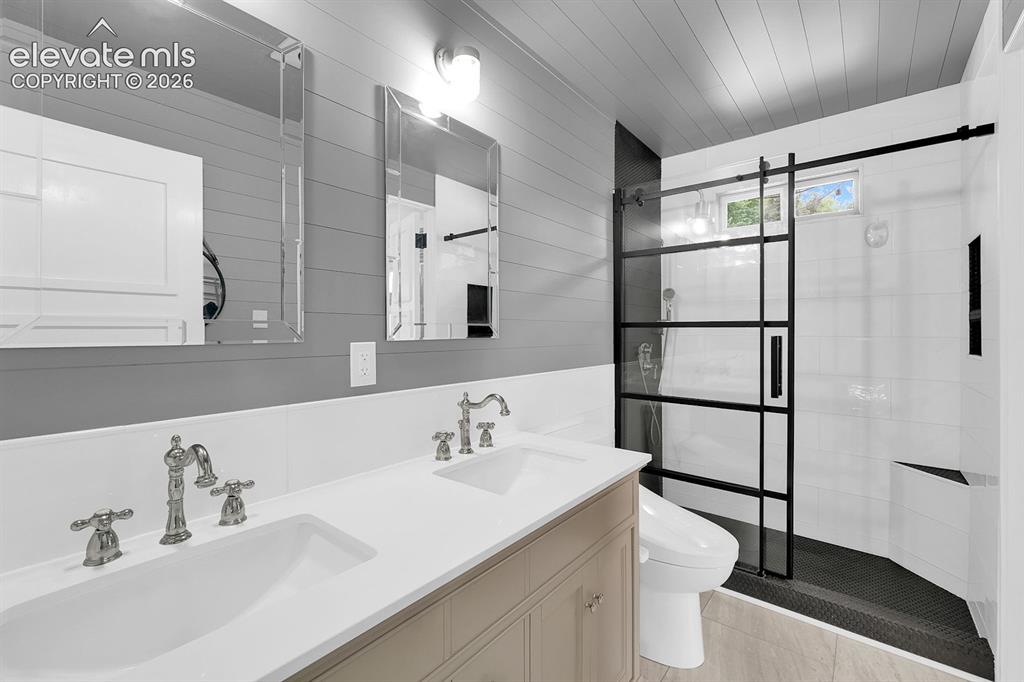 Image 12 of 33: Modern bathroom featuring a dual vanity with undermount sinks, polished chr