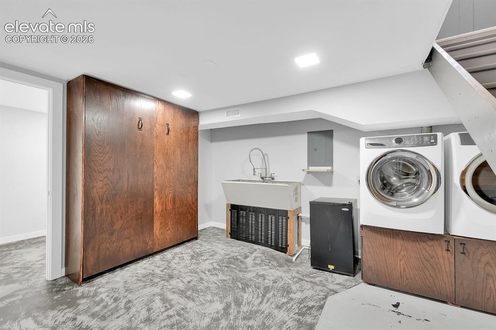 Image 18 of 33: Basement laundry area and Murphy-bed.