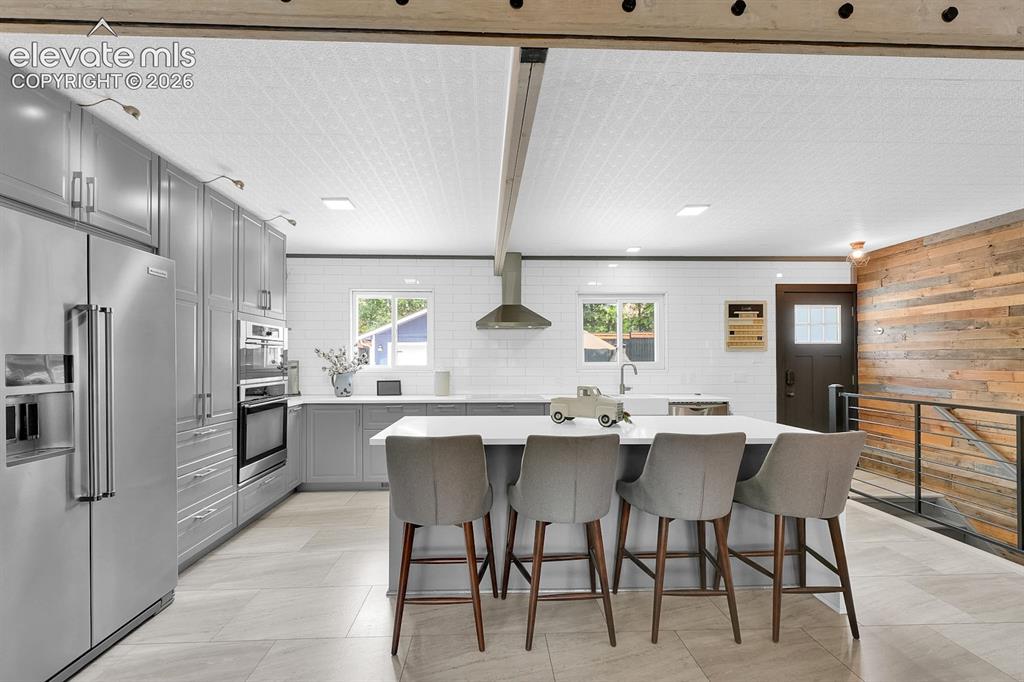 Image 2 of 33: Contemporary kitchen featuring a large island with seating, stainless steel