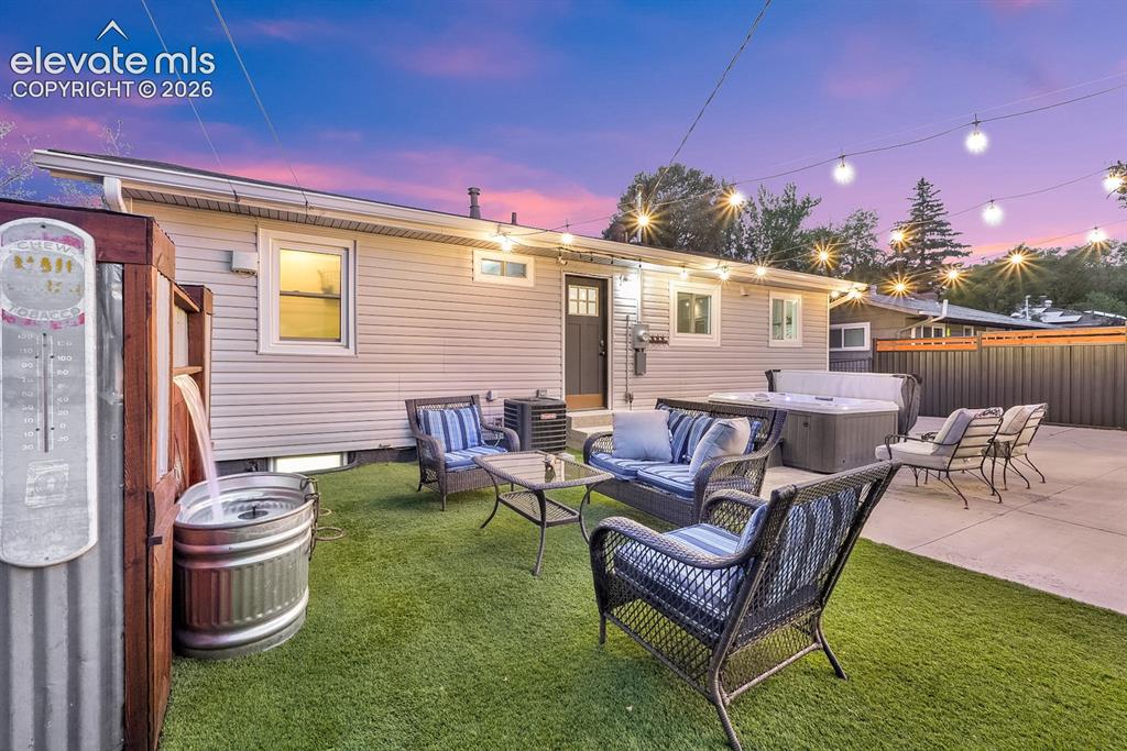 Image 21 of 33: Expansive backyard featuring artificial turf, a concrete patio, and a built